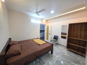 a bedroom with a bed and a chair in it at AJS Elite Rooms in Nagari