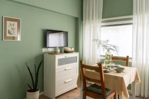 a dining room with a table and a tv on a dresser at Dotan's Boutique Studios - By The Beach! in Tel Aviv +112 photos