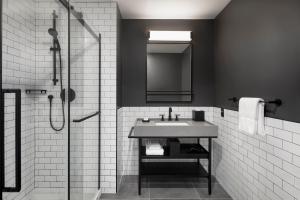 a black and white bathroom with a sink and a shower at New Moxy Ottawa Downtown in Ottawa +32 photos