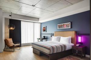 a bedroom with a king sized bed and a purple wall at New Moxy Ottawa Downtown in Ottawa