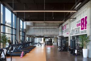 a gym with rows of exercise equipment in a building at New Moxy Ottawa Downtown in Ottawa