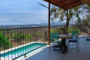 a balcony with a table and chairs and a pool at 6-Private Pool and View of Lake Chapala in Chapala