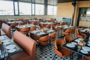 a dining room with tables and orange chairs at Rivotel The Luxury Hotel in Chākan