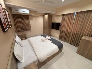 a bedroom with a large bed and a television at Rivotel The Luxury Hotel in Chākan