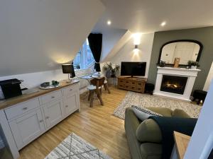 a living room with a couch and a fireplace at The Canongate Coorie in Jedburgh +30 photos