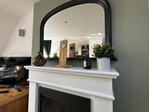 a mirror over a fireplace in a living room at The Canongate Coorie in Jedburgh