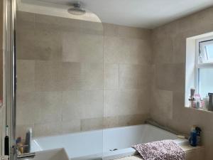 a bathroom with a bath tub and a window at Ilsyn Grove in Brislington
