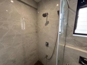 a bathroom with a shower with a glass door at Rivotel The Luxury Hotel in Chākan +44 photos