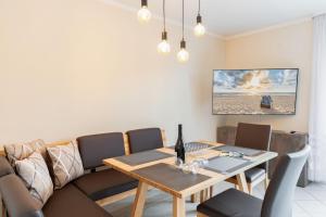 a dining room with a table and a couch at Strandurlaub Baabe - Bade- & Saunawelt täglich inklusive in Baabe