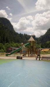 a child playing on a slide at a playground at Appartement-Edelweiss in Altenmarkt im Pongau