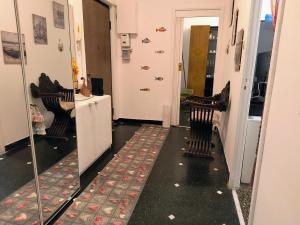 a hallway with two chairs and a door with a mirror at Pineta Holiday Home in Genoa