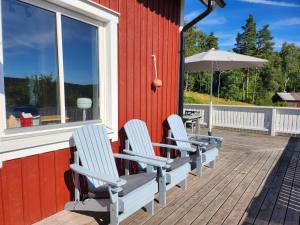 four chairs on a deck with an umbrella at StayinDalsland in Dals Långed