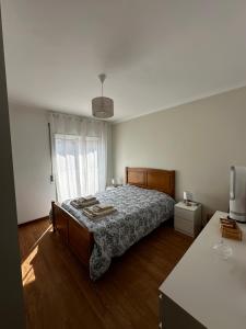 a bedroom with a bed and a large window at Apartamento Jardim do Sol in Macedo de Cavaleiros