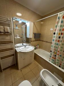 a bathroom with a sink and a tub and a toilet at Apartamento Jardim do Sol in Macedo de Cavaleiros