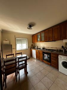 a kitchen with wooden cabinets and a table and chairs at Apartamento Jardim do Sol in Macedo de Cavaleiros