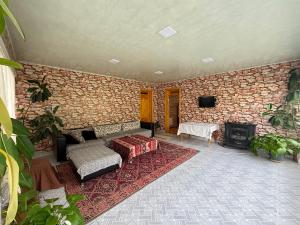 a stone walled room with a couch and a fireplace at Panoramic apartment in Gabala