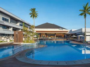 a large swimming pool in front of a building at Novotel Pontianak Convention Centre in Pontianak