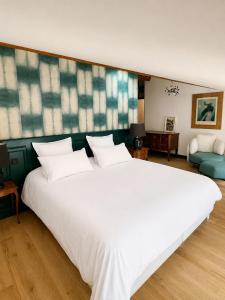 a large bed in a room with a large white bed at La Maison du 19 in Cluny
