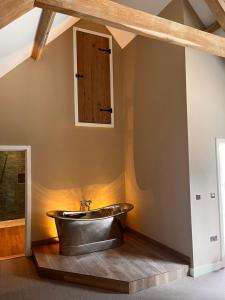 a bathroom with a tub in the corner of a room at The Harcourt Arms in Witney +48 photos