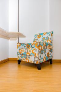 a colorful couch in a room with a wooden floor at Landmark Hotel Nanyuki in Nanyuki