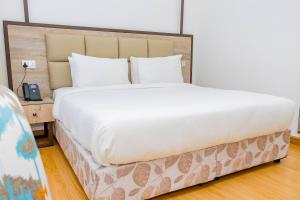 a large bed in a room with a telephone at Landmark Hotel Nanyuki in Nanyuki