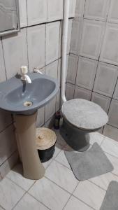 a bathroom with a blue sink and a toilet at Pousada 3 Bruxas Casa de Hóspedes in São Thomé das Letras