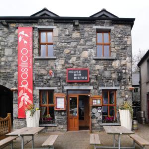 ein Gebäude mit Bänken davor in der Unterkunft The Coach House Hotel in Oranmore