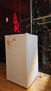 a white refrigerator sitting on top of a wooden floor at Trébol Hotel in Yurimaguas