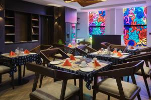 a dining room with tables and chairs and colorful windows at Black Muse Residence in Benin City