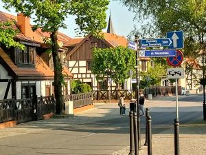 two people walking down a street with street signs at Domki Przy Pracowni in Wytowno +19 photos