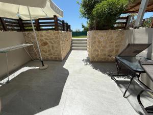 a patio with an umbrella and a table and chairs at Filippos House in Preveza