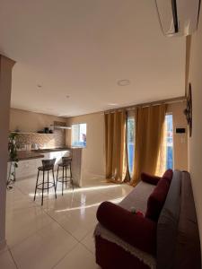 a living room with a couch and a kitchen at Lofts Serena - No Centro de Itacaré, a passos da Pituba in Itacaré