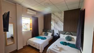 a bedroom with two beds and a mirror at Trébol Hotel in Yurimaguas