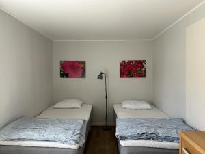 Zwei Betten in einem Zimmer mit zwei Bildern an der Wand in der Unterkunft Olles in Vessigebro