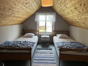 zwei Betten in einem Dachzimmer mit Fenster in der Unterkunft Olles in Vessigebro + 1 Foto