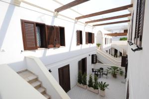 een terras met uitzicht op een wit gebouw bij Carmelina 3 in Marina di Pescoluse