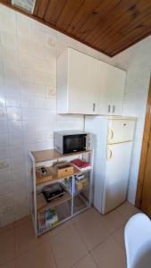 a small kitchen with a white refrigerator and a table at Casa da Cerca in Cenlle +4 photos
