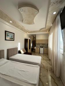 a bedroom with two beds and a kitchen at Beachfront Hotel Palma - Jaz in Budva