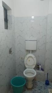 ein Badezimmer mit Toilette und grünem Eimer in der Unterkunft Joymak in Narok