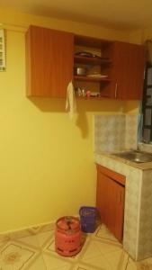 eine Küche mit einer gelben Wand und einem Eimer in der Unterkunft Joymak in Narok