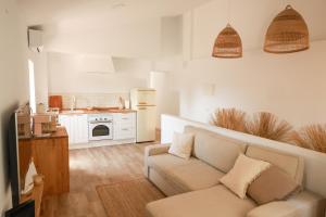 a living room with a couch and a kitchen at Apartaments Bellreguard in Papiol