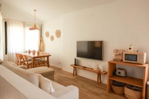 a living room with a couch and a tv and a table at Apartaments Bellreguard in Papiol