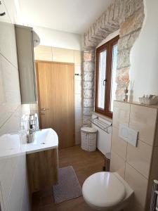 a bathroom with a white sink and a toilet at Tea Rooms II in Bale +8 photos