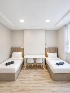 two beds in a room with a table at Central Room to Rent in Plymouth