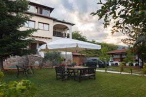 a table and chairs with an umbrella in front of a house at Villa Lito in Litochoro