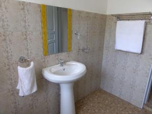 a bathroom with a sink and a mirror at Delhi Gardens Hotel in Fort Portal +8 photos