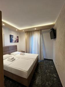 a bedroom with a large bed and a television at Beachfront Hotel Palma - Jaz in Budva