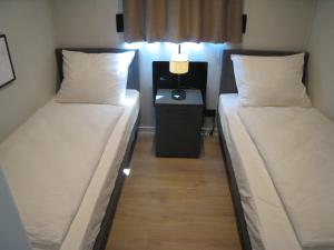 a room with two beds and a table with a lamp at Luxe Boshuisje Lodge Wildblick, adults only Haarle, Sallandse Heuvelrug in Haarle