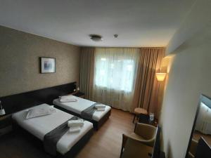 a hotel room with two beds and a window at Hotel Nord in Ploieşti +48 photos