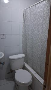 a bathroom with a toilet and a shower curtain at Hostal Mejillones in Mejillones